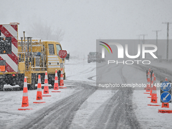 A road is being closed with a stop sign during heavy snowfall in Springfield, in the Selwyn District of Canterbury, in the South Island, New...