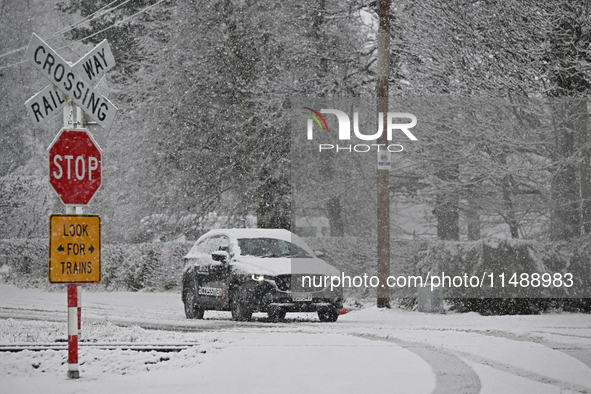 A car is driving on a snow-covered road during heavy snowfall in Springfield, in the Selwyn District of Canterbury, in the South Island, New...