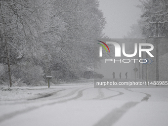 People are crossing a snow-covered road during heavy snowfall in Springfield, in the Selwyn District of Canterbury, in the South Island, New...