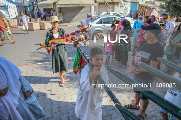 Young followers of a Sufi order are carrying Sufi flags as they are preparing for the start of the annual procession of Sidi Bou Said in Ari...