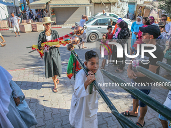 Young followers of a Sufi order are carrying Sufi flags as they are preparing for the start of the annual procession of Sidi Bou Said in Ari...