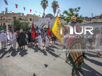 A devotee from a Sufi order in traditional Tunisian dress is representing the city's patron saint on horseback and leading the annual proces...