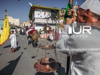 A devotee from a Sufi order in traditional Tunisian dress is representing the city's patron saint on horseback and leading the annual proces...