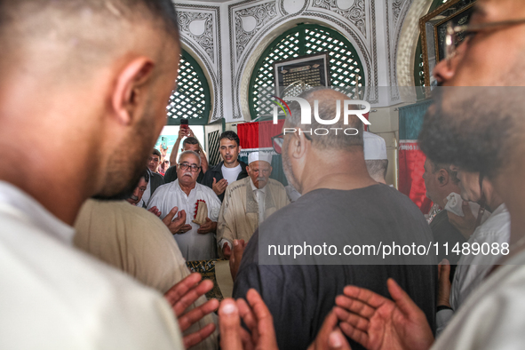 Devotees, leaders of a Sufi order, and local residents are reciting some suras from the holy book of Islam, the Koran (Qur'an), at the mauso...