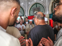 Devotees, leaders of a Sufi order, and local residents are reciting some suras from the holy book of Islam, the Koran (Qur'an), at the mauso...