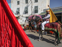 A devotee from a Sufi order in traditional Tunisian dress is representing the city's patron saint on horseback and leading the annual proces...