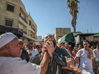 A follower of a Sufi order is swallowing pieces of glass while in a state of trance during the annual procession of Sidi Bou Said in Ariana,...