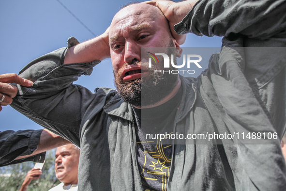 A follower of a Sufi order is swallowing pieces of glass and has a bloody mouth while in a state of trance during the annual procession of S...