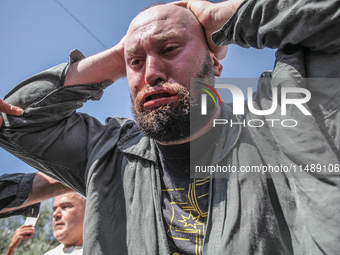 A follower of a Sufi order is swallowing pieces of glass and has a bloody mouth while in a state of trance during the annual procession of S...