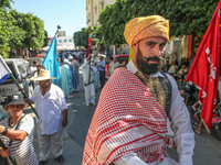 A devotee from a Sufi order in traditional Tunisian dress is representing the city's patron saint on horseback and leading the annual proces...