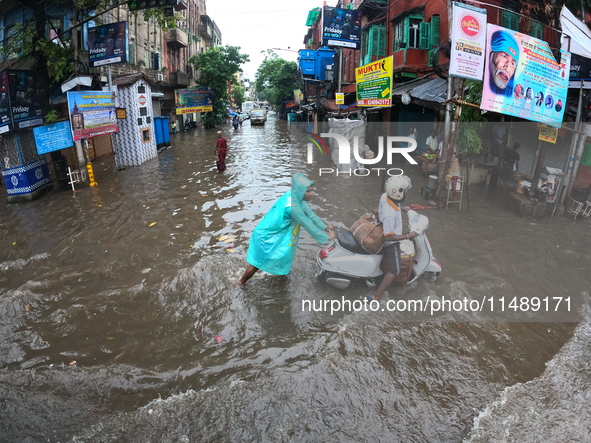 Vehicles are driving through a flooded street during the heavy monsoon rain in Kolkata, India, on August 18, 2024. 