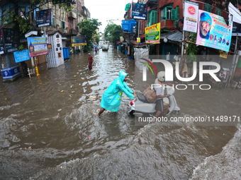 Vehicles are driving through a flooded street during the heavy monsoon rain in Kolkata, India, on August 18, 2024. (