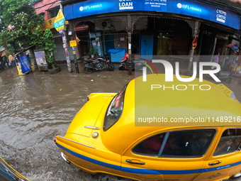 Vehicles are driving through a flooded street during the heavy monsoon rain in Kolkata, India, on August 18, 2024. (