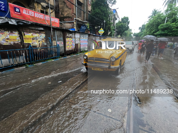 Vehicles are driving through a flooded street during the heavy monsoon rain in Kolkata, India, on August 18, 2024. 