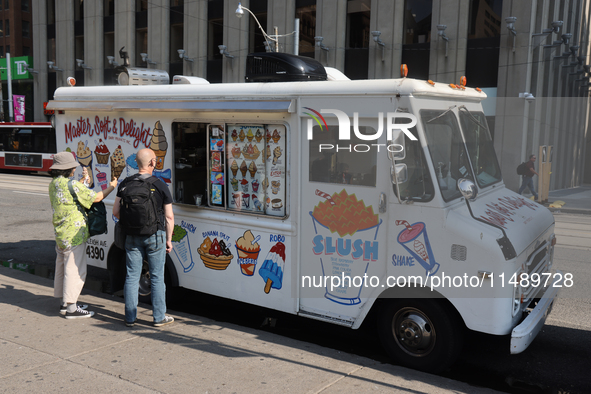 People are purchasing ice cream from an ice cream truck at Nathan Philips Square in downtown Toronto, Ontario, Canada, on August 14, 2024. 