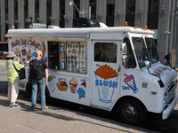 People are purchasing ice cream from an ice cream truck at Nathan Philips Square in downtown Toronto, Ontario, Canada, on August 14, 2024. (