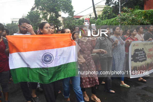 Junior doctors are holding India's national flag and marching on the street during a protest condemning the rape and murder of a trainee med...