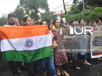 Junior doctors are holding India's national flag and marching on the street during a protest condemning the rape and murder of a trainee med...