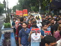 Doctors are holding posters and marching on the street during a protest condemning the rape and murder of a trainee medic at a government-ru...