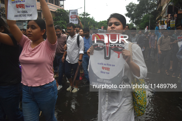 Junior doctors are holding posters and marching on the street during a protest condemning the rape and murder of a trainee medic at a govern...