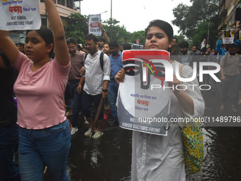 Junior doctors are holding posters and marching on the street during a protest condemning the rape and murder of a trainee medic at a govern...