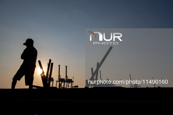 A man is walking near the port area in Jakarta, Indonesia, on August 18, 2024. 