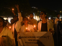 Medical professionals and students are shouting slogans and holding lit candles in a protest demanding justice following the rape and murder...