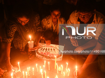 Medical professionals and students are holding placards and lighting candles in a protest demanding justice following the rape and murder of...