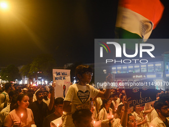 A girl is waving the Indian National Flag in a protest march by medical professionals and students demanding justice following the rape and...