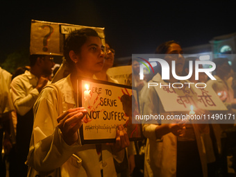 Medical professionals and students are holding lit candles in a protest march demanding justice following the rape and murder of a trainee m...