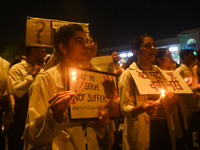 Medical professionals and students are holding lit candles in a protest march demanding justice following the rape and murder of a trainee m...