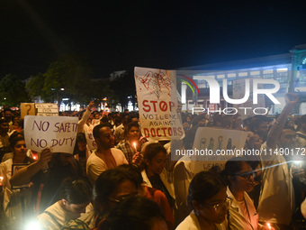 Medical professionals and students are holding placards and shouting slogans in a protest march demanding justice following the rape and mur...