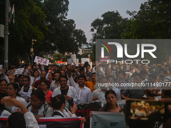 Medical professionals and students are holding placards and shouting slogans in a protest march demanding justice following the rape and mur...