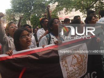 Medical professionals and students are holding placards and shouting slogans in a protest march demanding justice following the rape and mur...