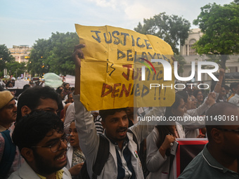 Medical professionals and students are holding placards and shouting slogans in a protest march demanding justice following the rape and mur...