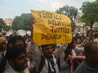 Medical professionals and students are holding placards and shouting slogans in a protest march demanding justice following the rape and mur...