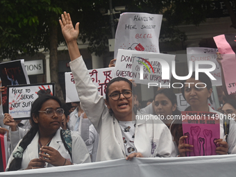 Medical professionals and students are holding placards and shouting slogans in a protest demanding justice following the rape and murder of...