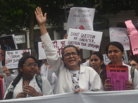 Medical professionals and students are holding placards and shouting slogans in a protest demanding justice following the rape and murder of...