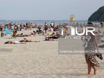 People are seen at the beach in Gdynia, Poland on August 18, 2024. (