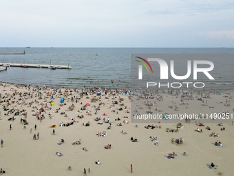 People are seen at the beach in Gdynia, Poland on August 18, 2024. (