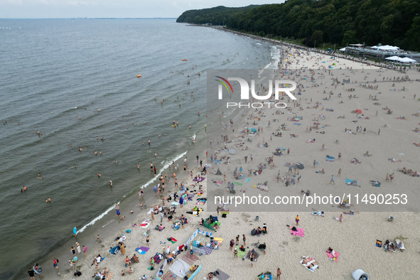 People are seen at the beach in Gdynia, Poland on August 18, 2024. 