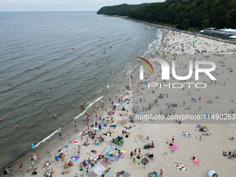 People are seen at the beach in Gdynia, Poland on August 18, 2024. (