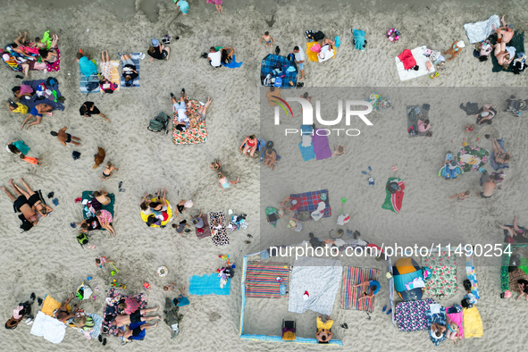 People are seen at the beach in Gdynia, Poland on August 18, 2024. 