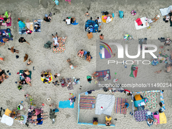 People are seen at the beach in Gdynia, Poland on August 18, 2024. (