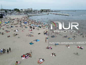 People are seen at the beach in Gdynia, Poland on August 18, 2024. (