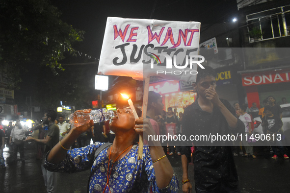 A woman is drinking water while protesting over the sexual assault and murder of a Kolkata woman doctor in Kolkata, India, on August 18, 202...