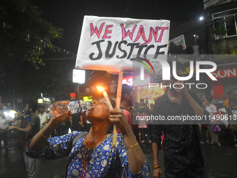 A woman is drinking water while protesting over the sexual assault and murder of a Kolkata woman doctor in Kolkata, India, on August 18, 202...