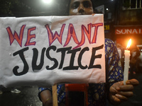 A woman is holding a placard and candle while protesting over the sexual assault and murder of a Kolkata woman doctor in Kolkata, India, on...