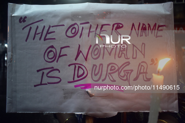 A woman is holding a placard and candle while protesting over the sexual assault and murder of a Kolkata woman doctor in Kolkata, India, on...