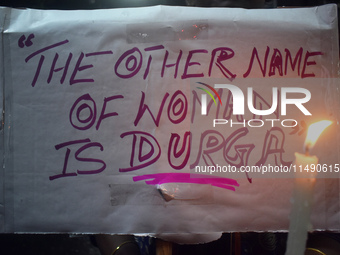 A woman is holding a placard and candle while protesting over the sexual assault and murder of a Kolkata woman doctor in Kolkata, India, on...